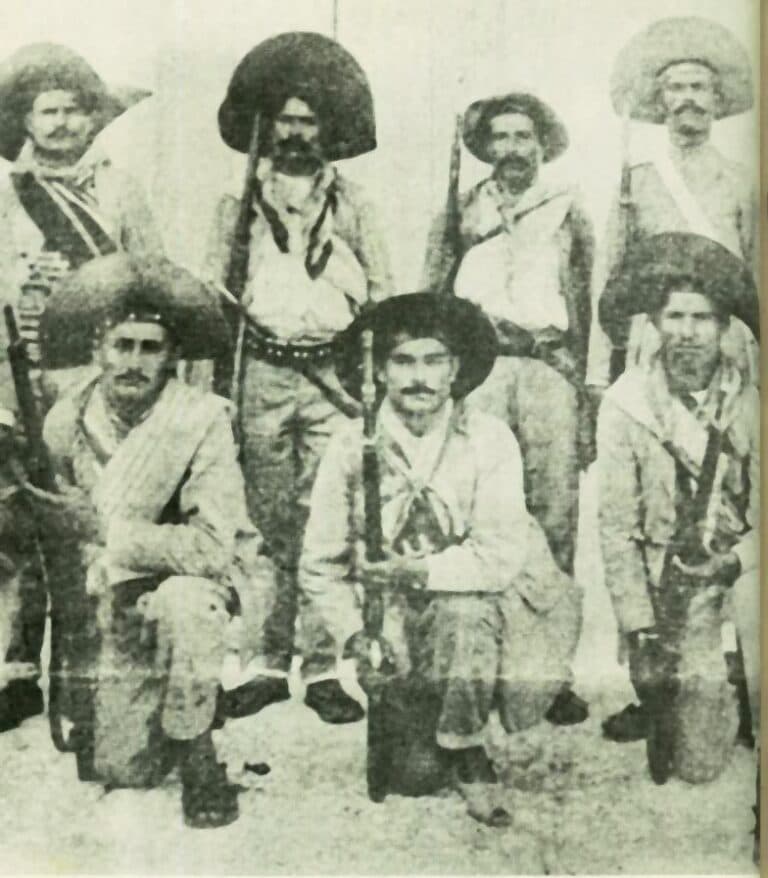 Grupo de cangaceiros com roupas tradicionais e chapéus, posando para foto.